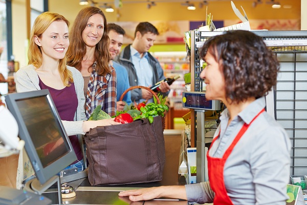 Woman with groceries waiting in line at the supermarket checkout